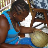 Surinam: eine Frau fertigt eine Schale aus einer Kalebasse.