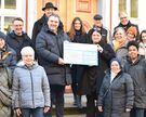 goetel Geschäftsführer Daniel Kleinbauer (6.v.l.) übergibt den Spendenscheck an die Helferinnen und Helfer des Heiligabendkreises in Duderstadt.